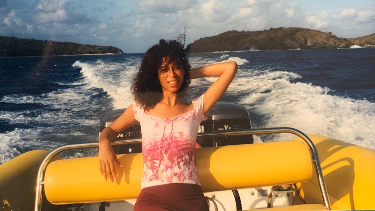 Lisa Phillips wearing a pink blouse and a brown skirt on a boat.