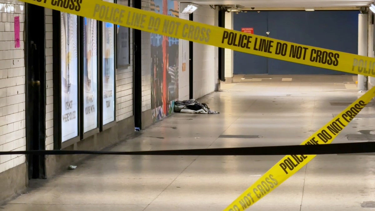 Caution tape reading "police line do not cross" blocks a corridor in Penn Station.