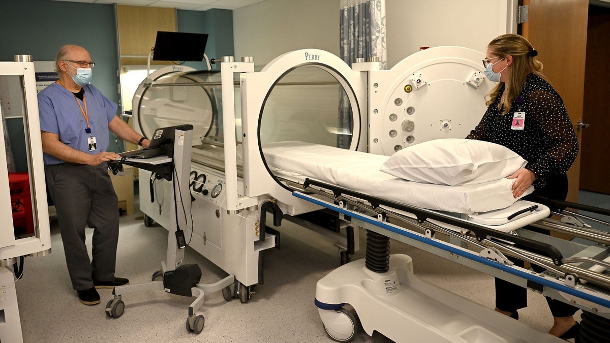 Dr. Elliot Lach, left, and program director Carolyn Blaney show one of two new hyperbaric chambers during a tour of a new wound healing and hyperbaric center at MetroWest Medical Center in Framingham, April 28, 2022.