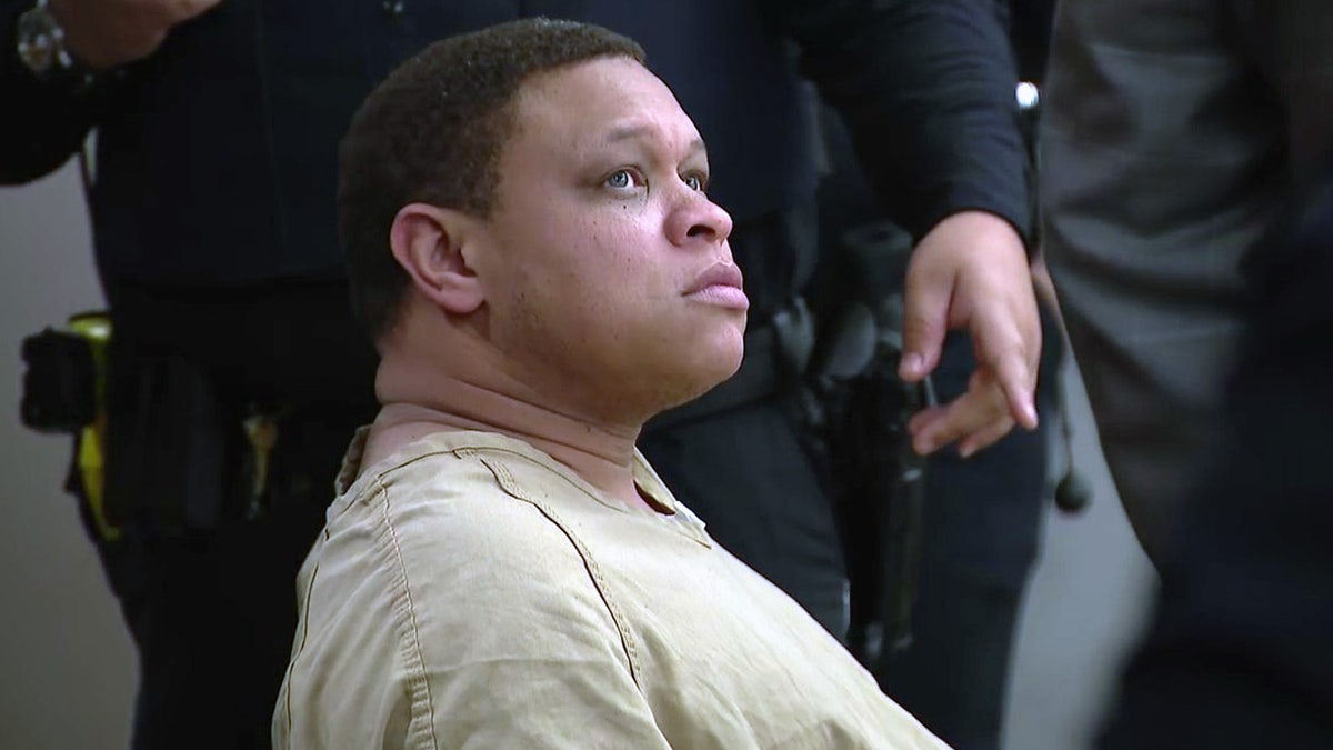Kendrick Finch sits in a tan jumpsuit at his bond hearing