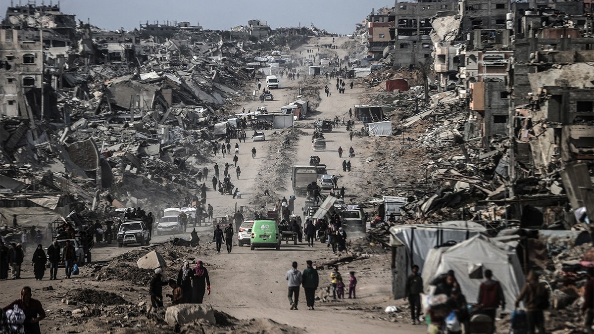 Palestinians travel in the ruins of Gaza City