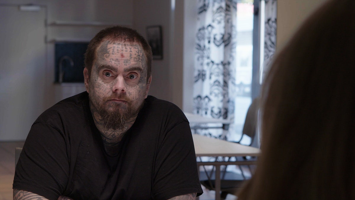 Isakin looking away from his daughter wearing a black shirt.