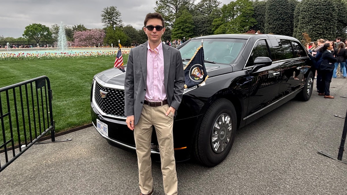 Eric Tarpinian-Jachym stands in front of a car