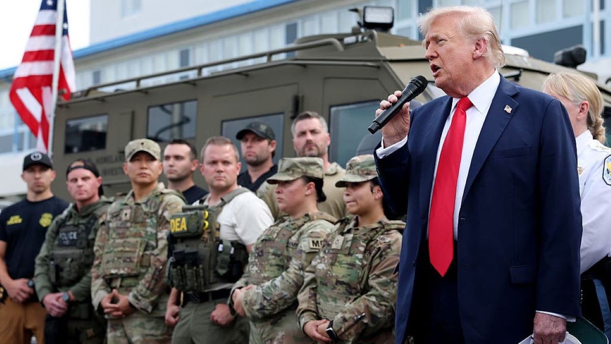 Donald Trump standing with federal law enforcement.