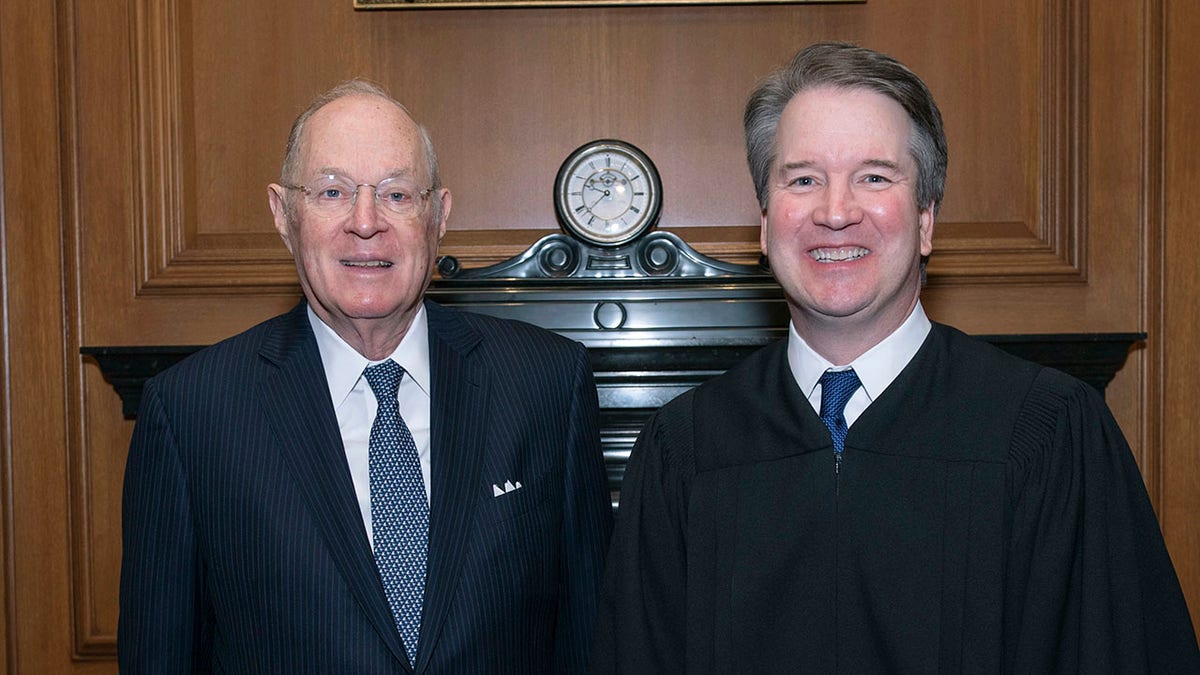 In this image provided by the U.S. Supreme Court, retired Justice Anthony M. Kennedy poses with his former law clerk Associate Justice Brett M. Kavanaugh on Nov. 8, 2018, at the Supreme Court in Washington, D.C. (Fred Schilling/Collection of the Supreme Court of the United States via AP)