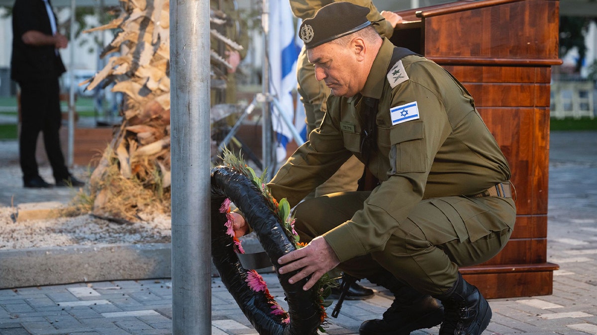 Eyal Zamir kneeling and laying a wreath at Nahal Oz base
