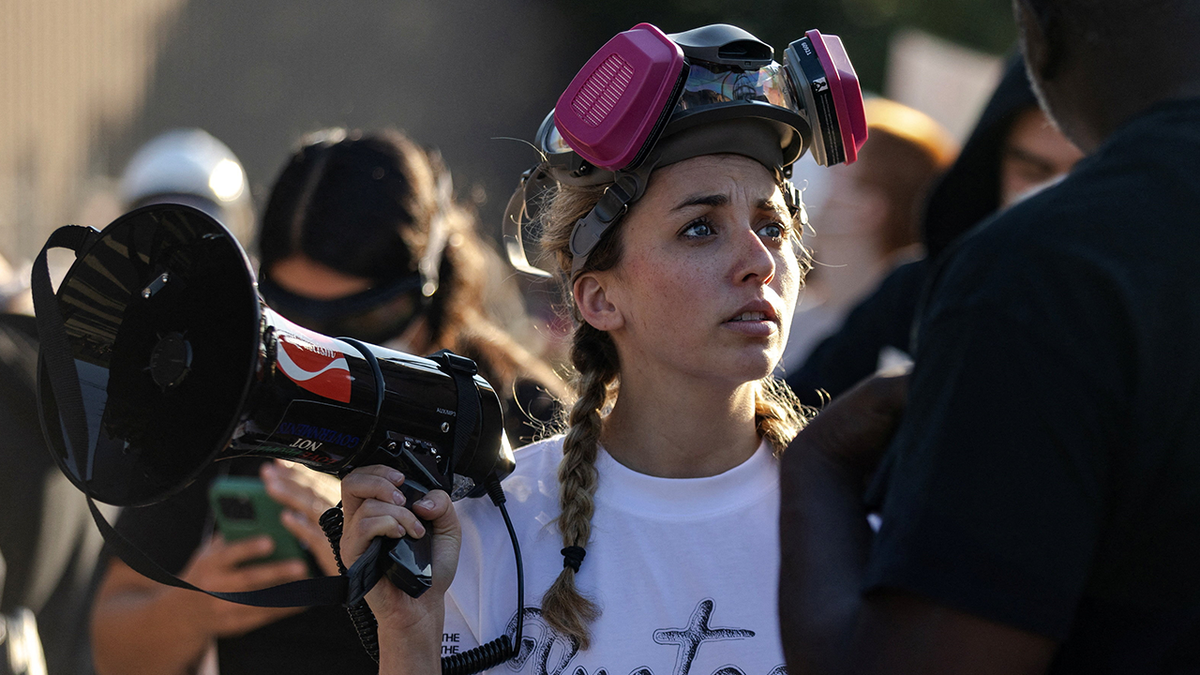 Kat Abughazaleh holds a megaphone at an anti-ICE protest