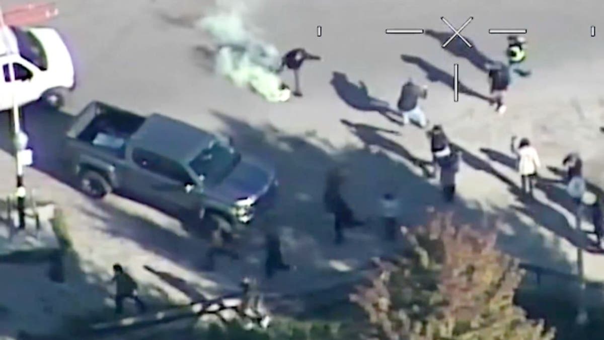 Aerial view of protesters fleeing tear gas during Chicago immigration raid.