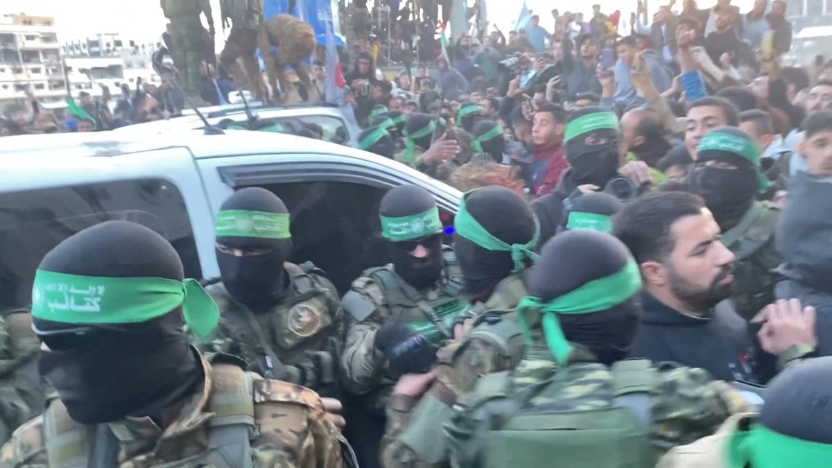 Hamas terrorists emerge in a show of strength escorting Red Cross vehicles carrying 3 Israeli hostages to be released as part of the cease-fire deal.