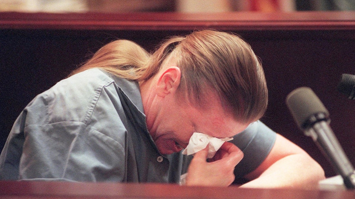 Aileen Wuornos crying in a light blue jumpsuit.