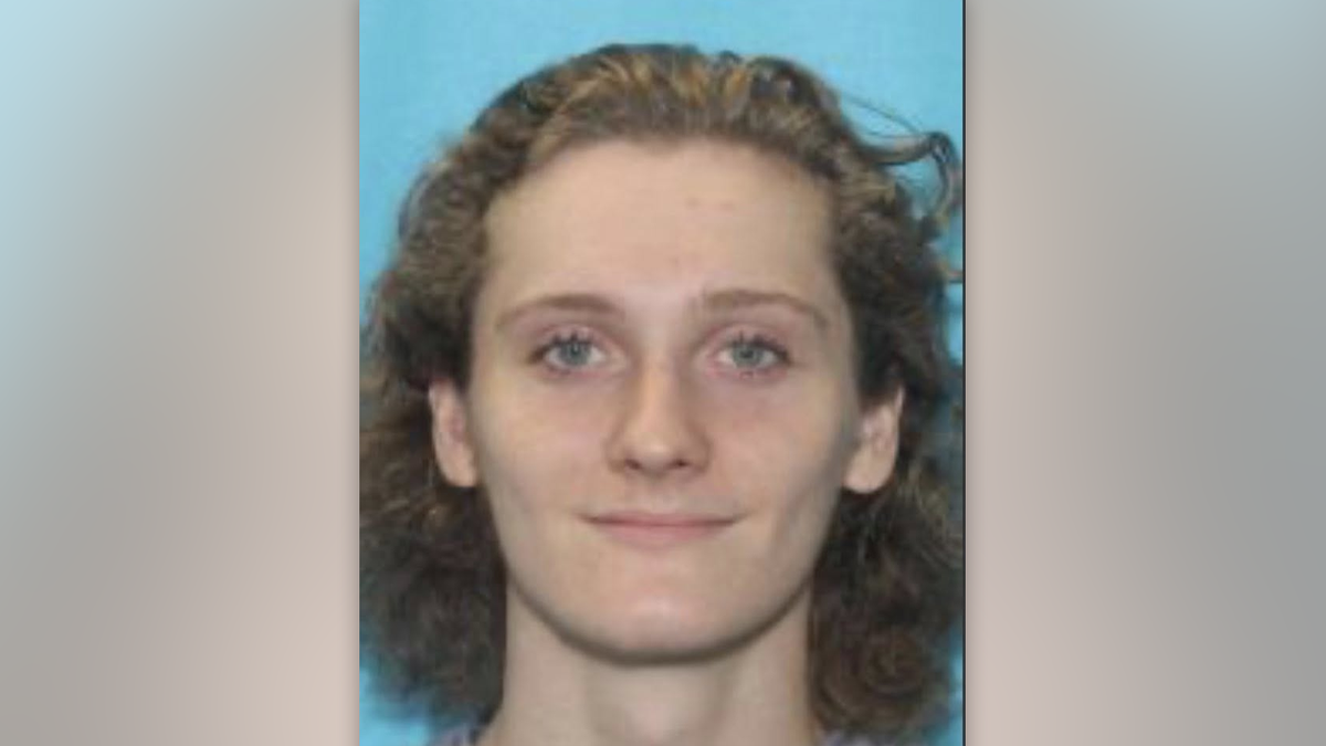 Driver's license photo of NC fugitive murder suspect Dominic Connelly smiling in front of a blue backdrop