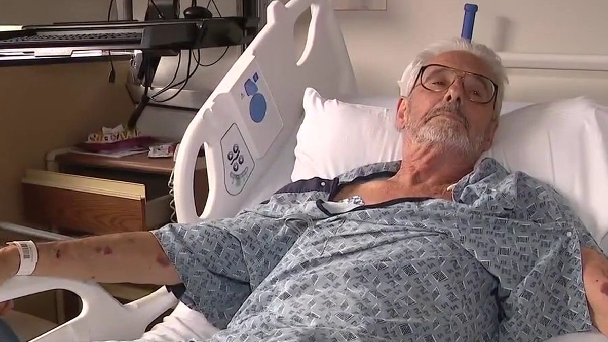 George Karkoc speaks with a reporter form his hospital bed