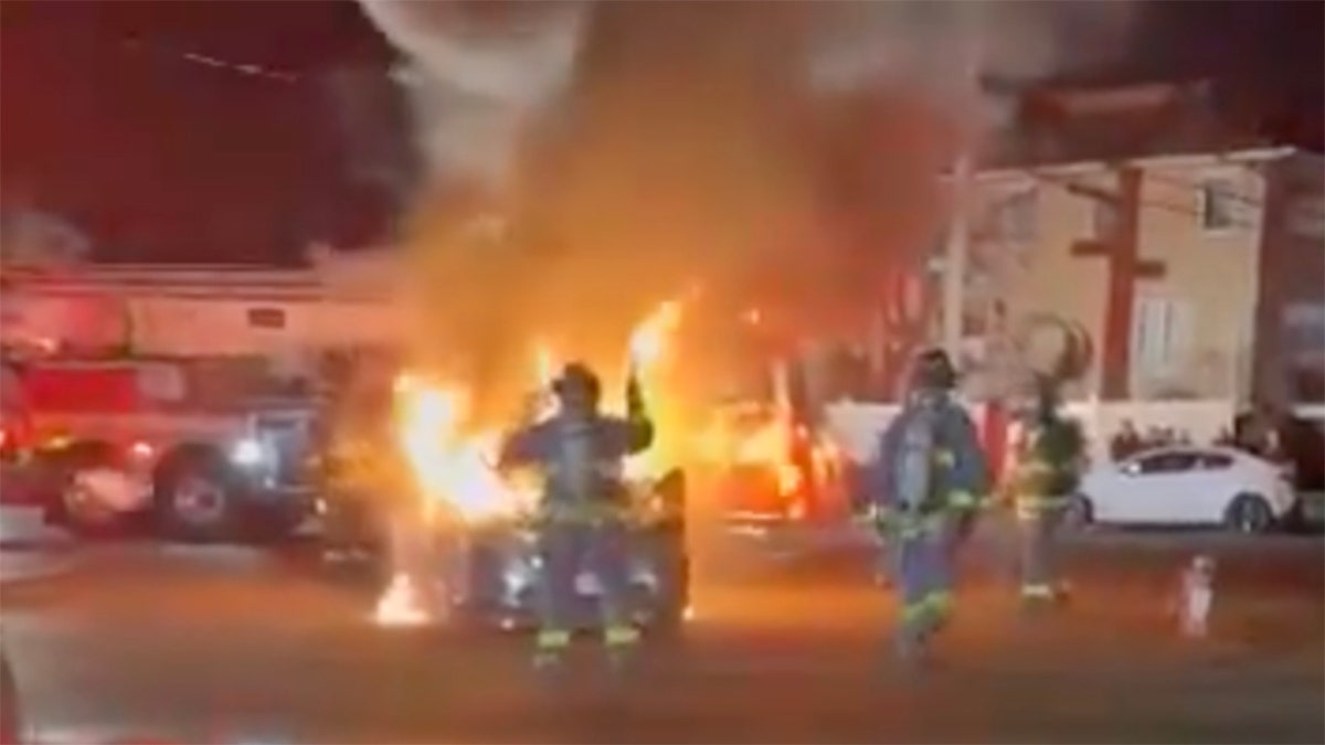 Firefights put out a car fire during a street takeover in New York City