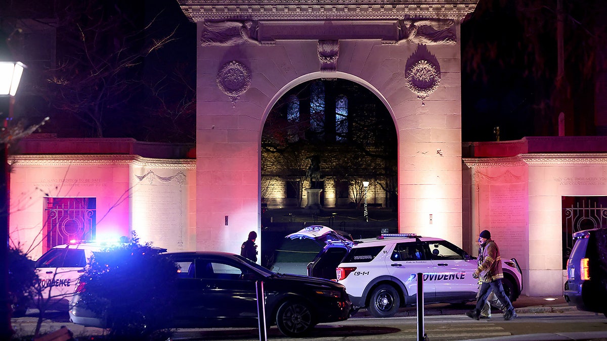 Police gather outside an entrance to Brown University in Providence, R.I., on Saturday, Dec. 13, 2025, during the investigation of a shooting. (AP Photo/Mark Stockwell)