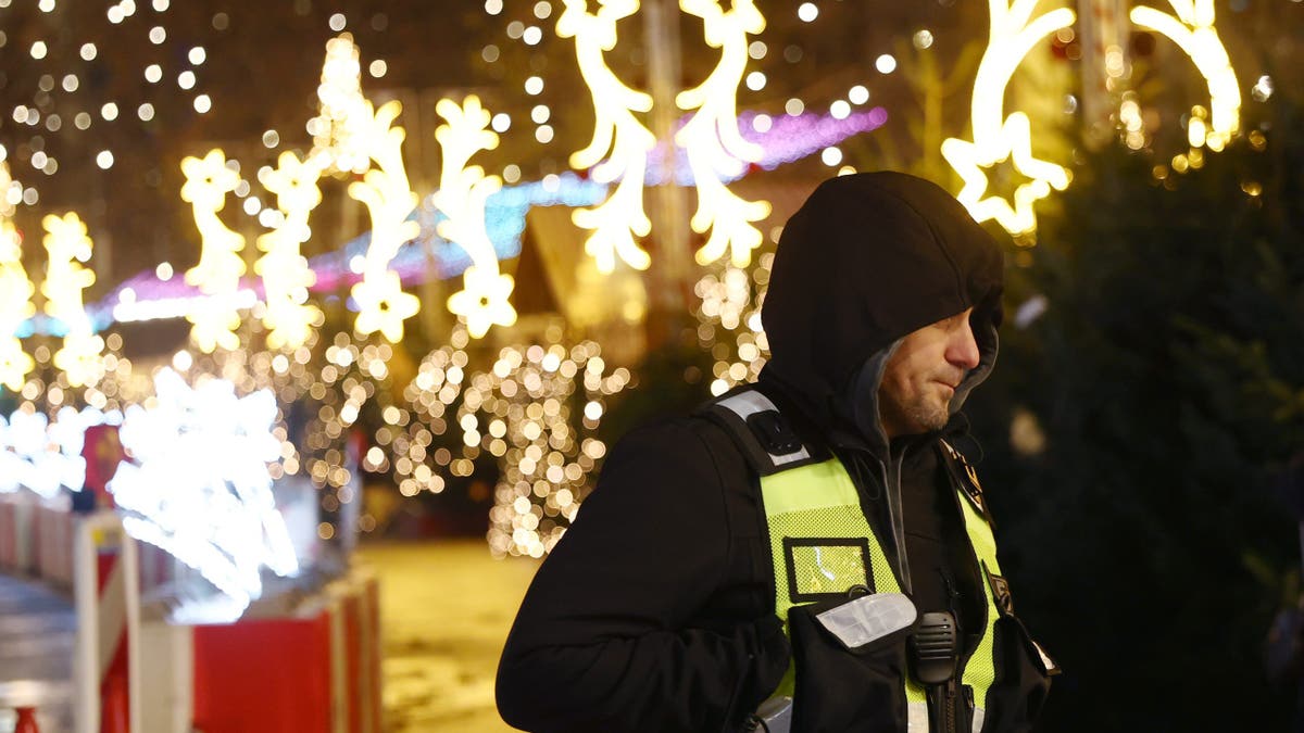 A member of security observes visitors walk among Christmas stalls at the opening day of the annual Christmas market at Breitscheidplatz on November 24, 2025 in Berlin, Germany. Christmas markets are opening today across the city and in many other cities across Germany. (Photo by Maryam Majd/Getty Images)