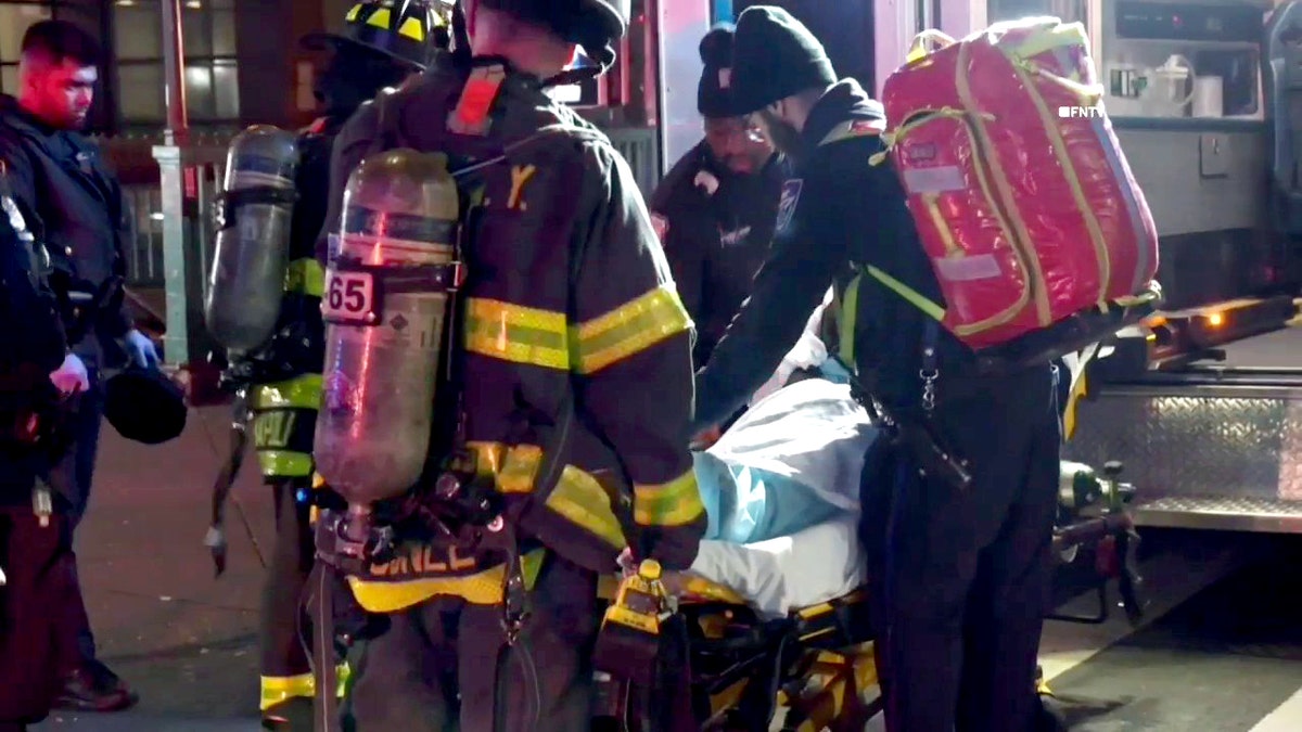 firefighters and paramedics help victim on a gurney