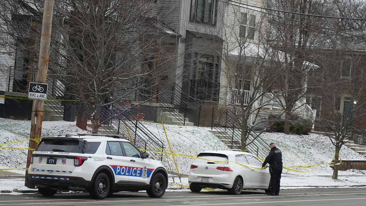 A Columbus police officer adjusts crime scene tape after officers responded to the home of Monique Tepe and Spencer Tepe