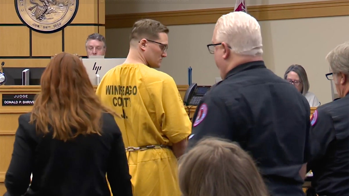 McKee appears in court, wearing a yellow jumpsuit