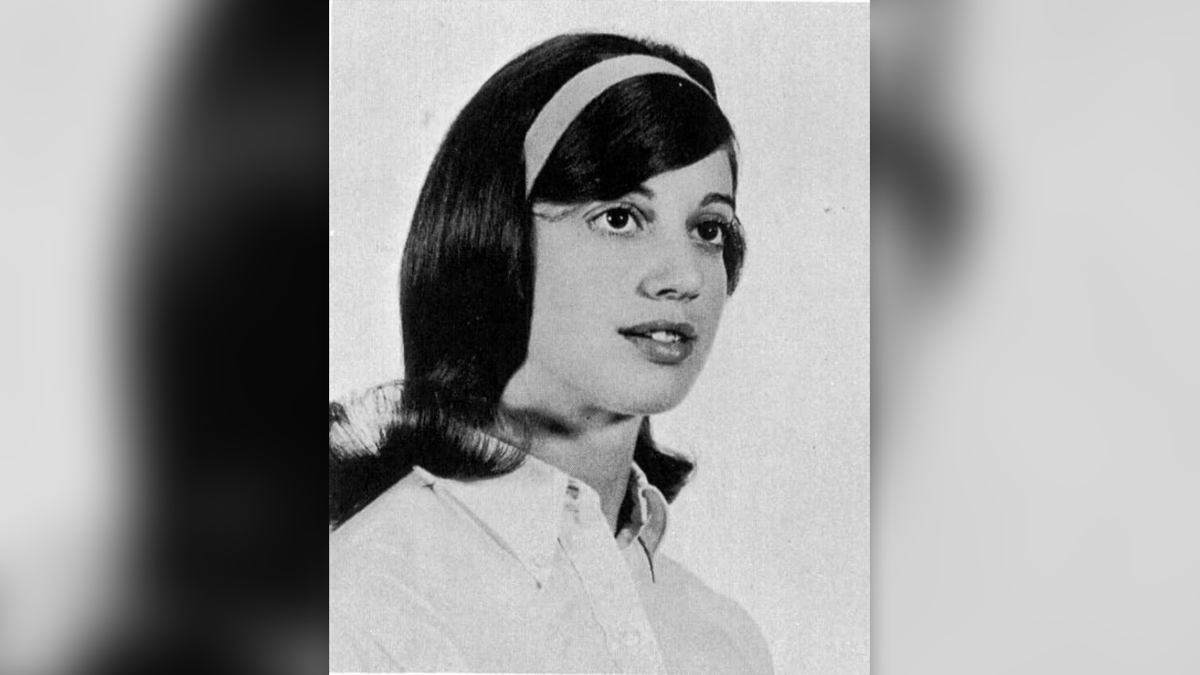 A black and white photo of Alys Eberhardt, who is wearing a hair band and white-collared shirt.