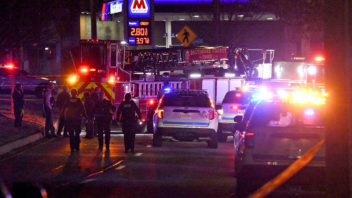 Police investigating a shooting in Baltimore at night.