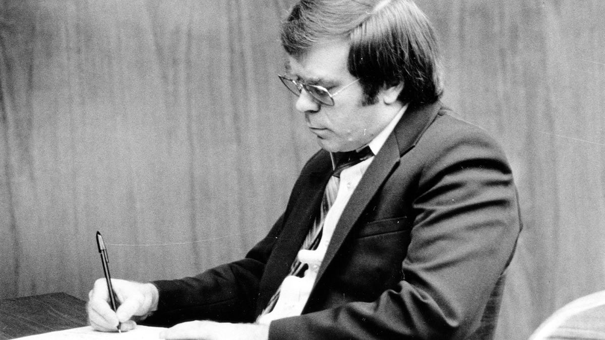 Richard Cottingham takes notes during his 1982 murder trial in a black and white photo