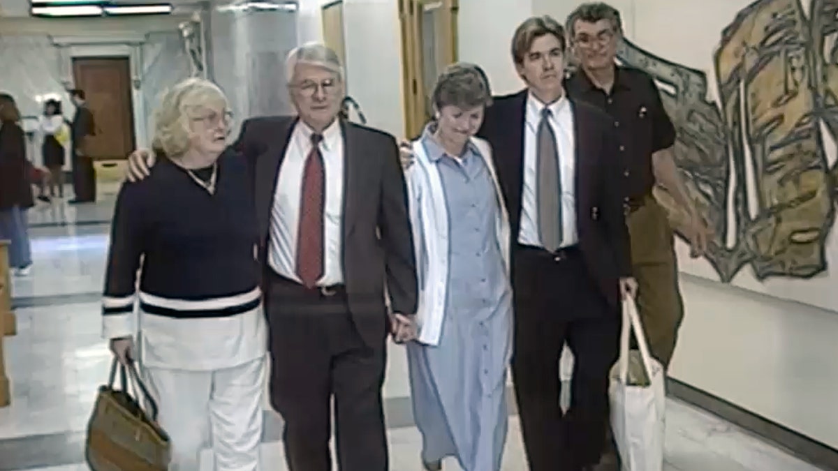Family members of Tim Moreau walk together inside a courthouse hallway