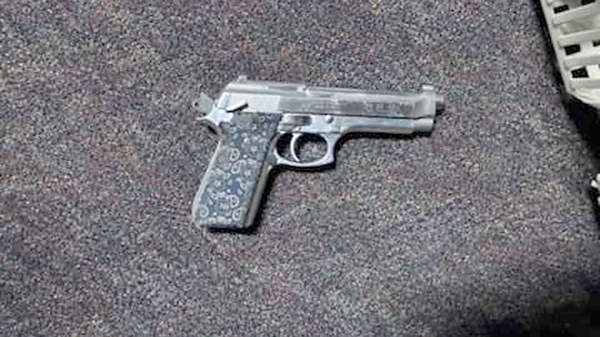 A photo of a gun on the floor.