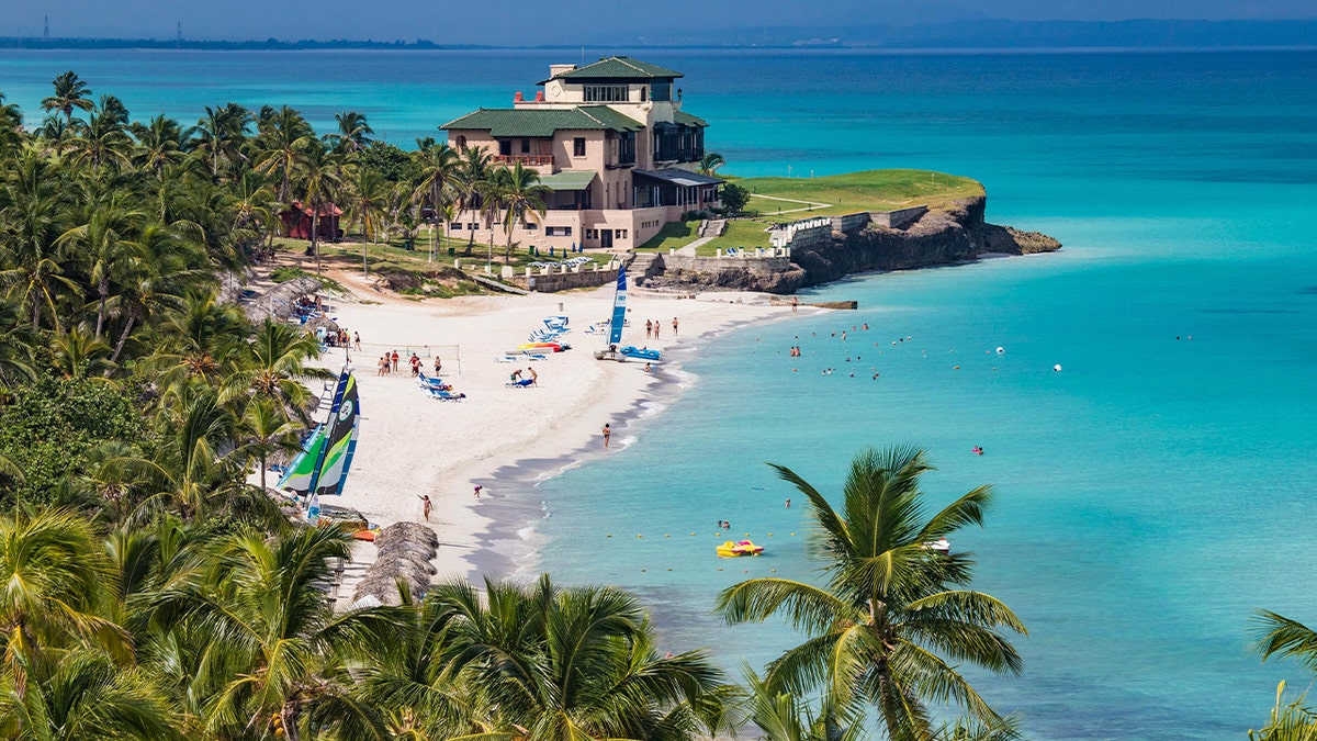 mansion at coastal city with tropical trees and beach