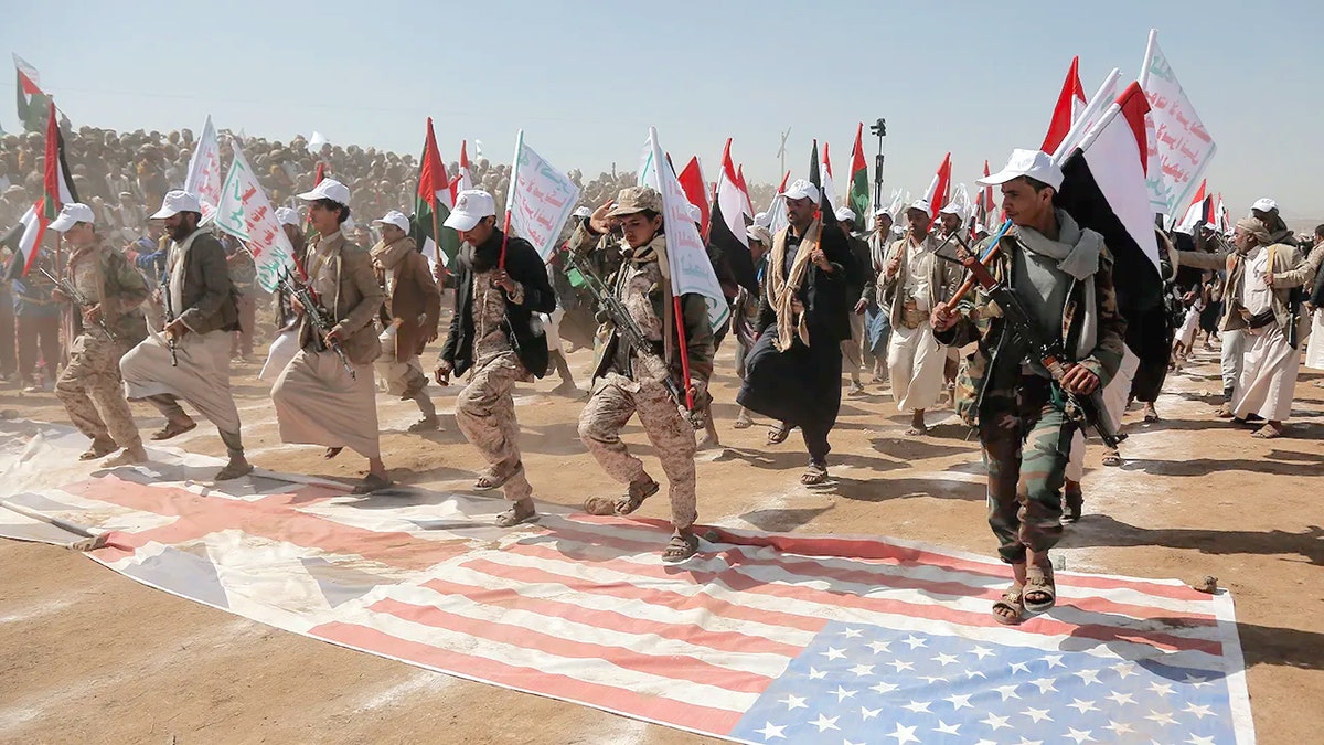 Houthi fighters trample U.S.,UK flags
