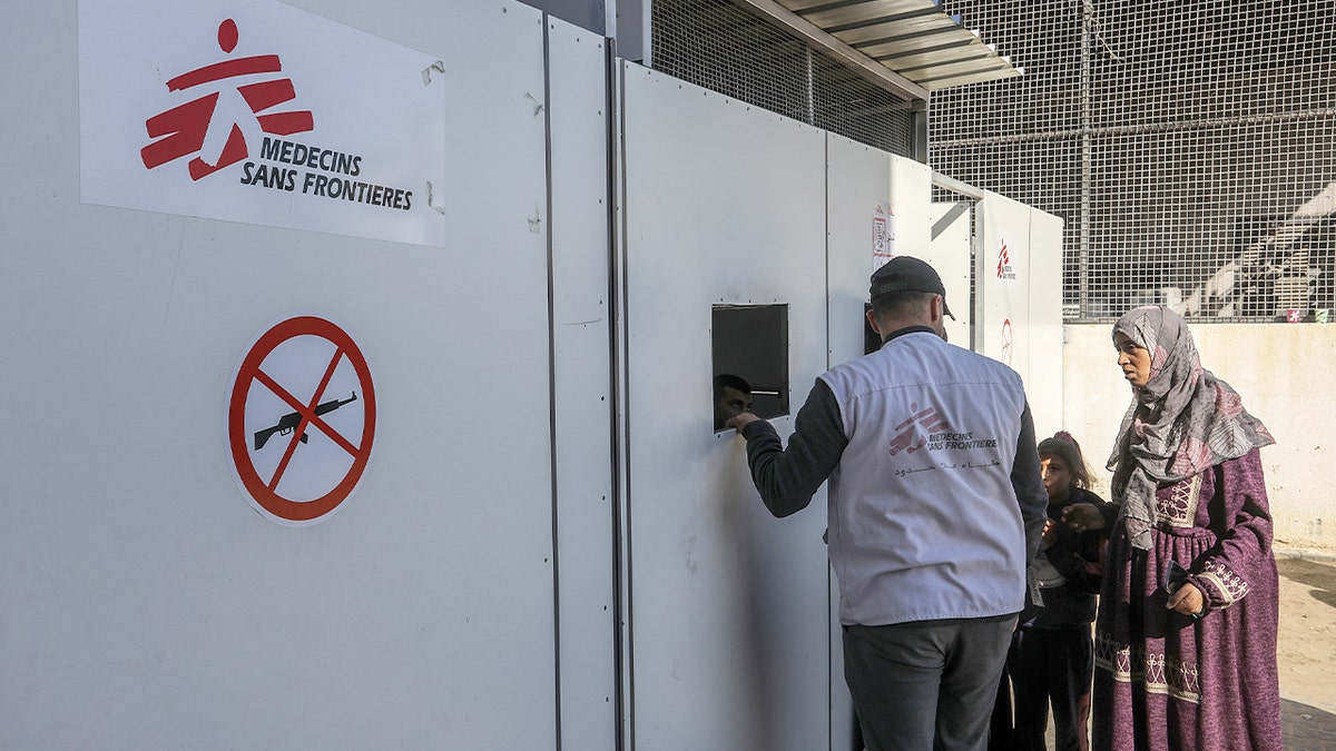 A Doctors Without Borders employee speaks with a patient inside a hospital ward operating with scarce resources.