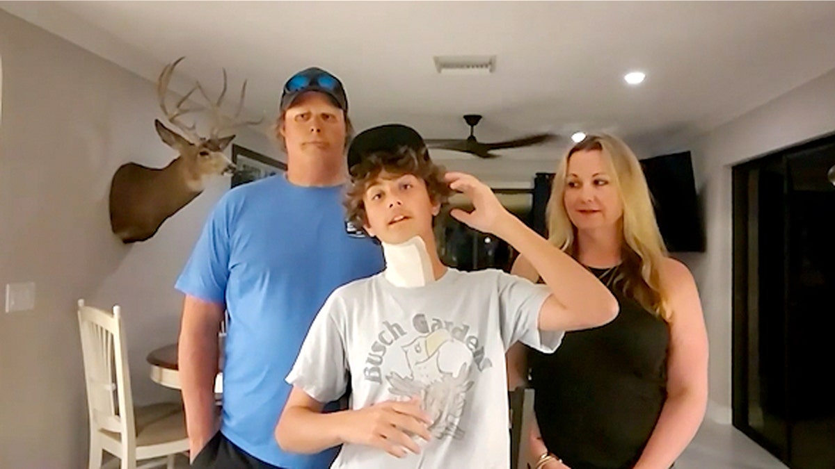 Teen standing with parents in an interview.