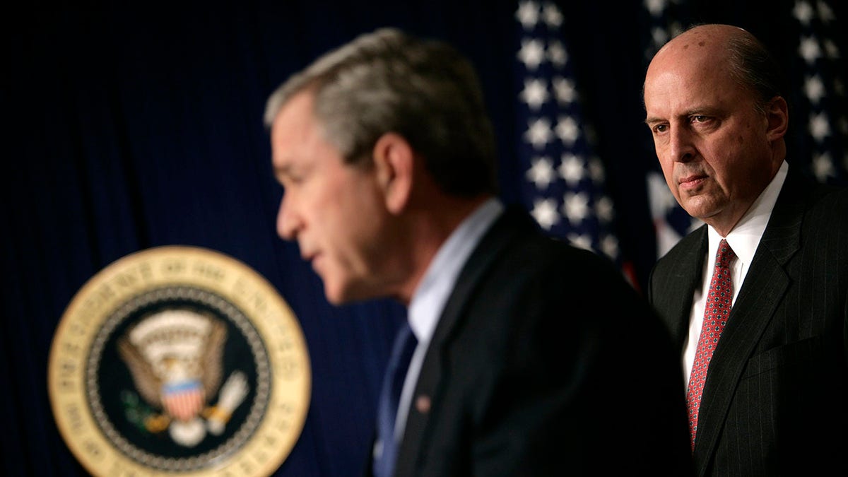 John Negroponte looks on while President Bush holds press conference