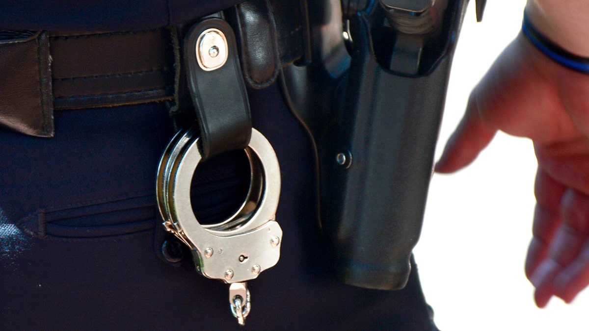 Handcuffs and gun on police belt